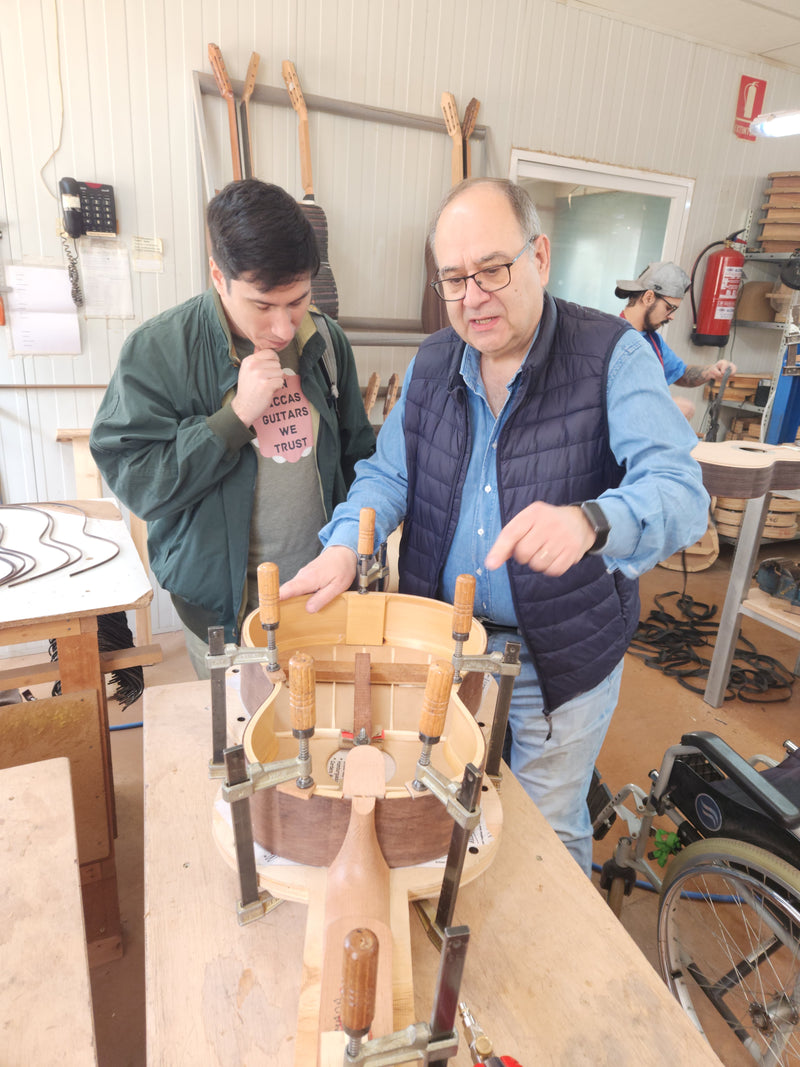 Two men working on a wooden project in a workshop.